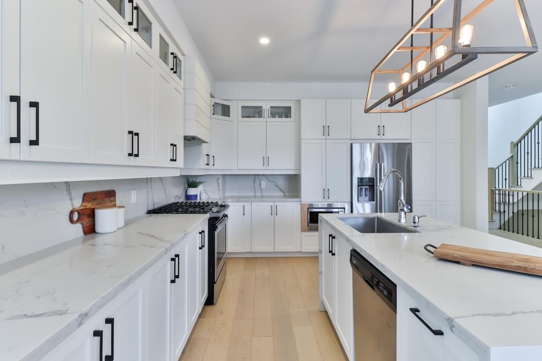 Modern kitchen with refinished white cabinets and warm wooden floor